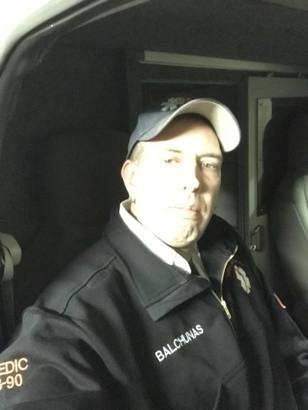 Brian sitting in an emergency vehicle taking a serious selfie.