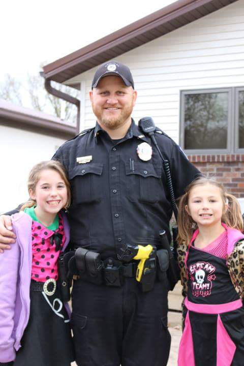 Timothy in police uniform with his two little girls