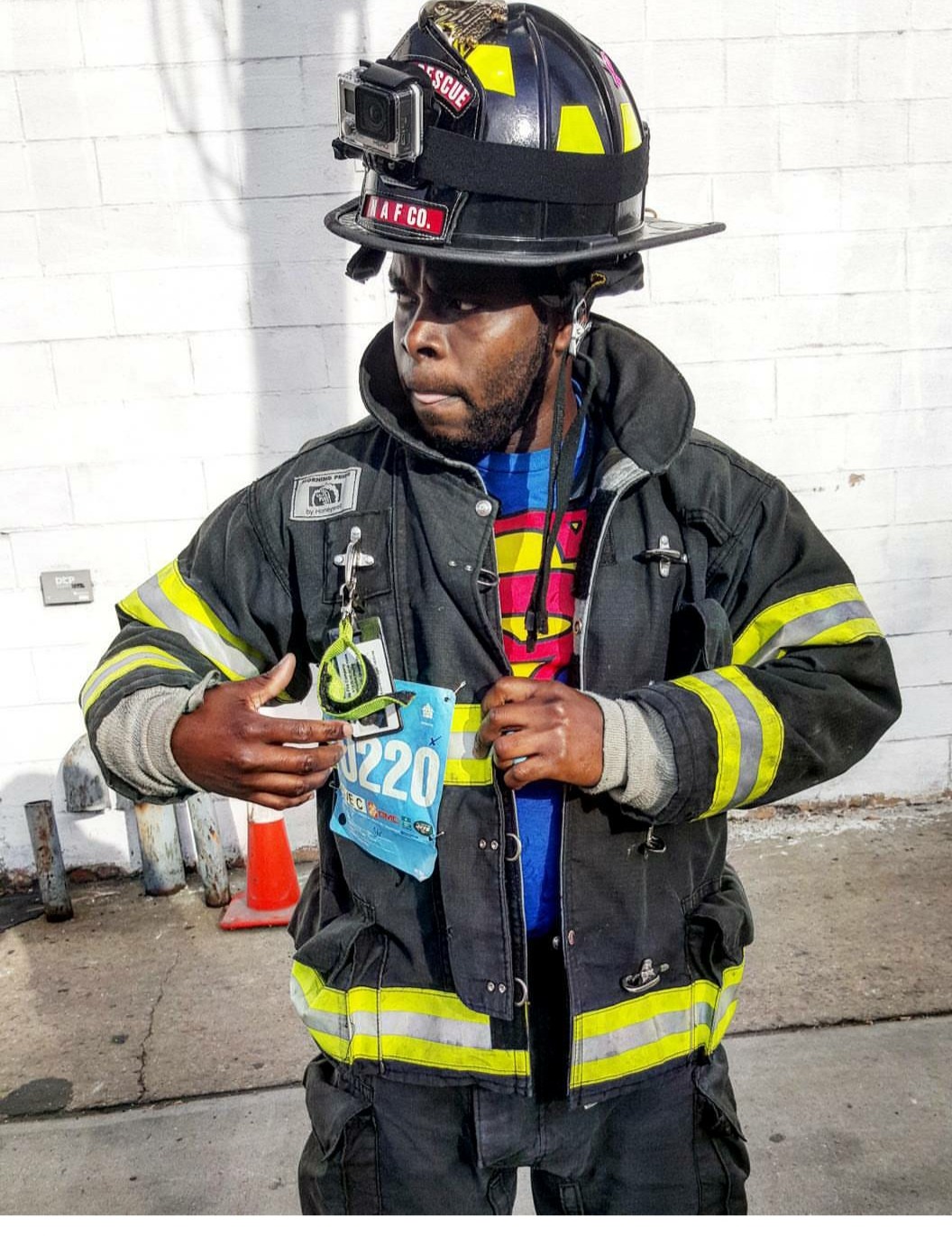 Rhodell in his firefighter uniform revealing a Superman shirt underneath.